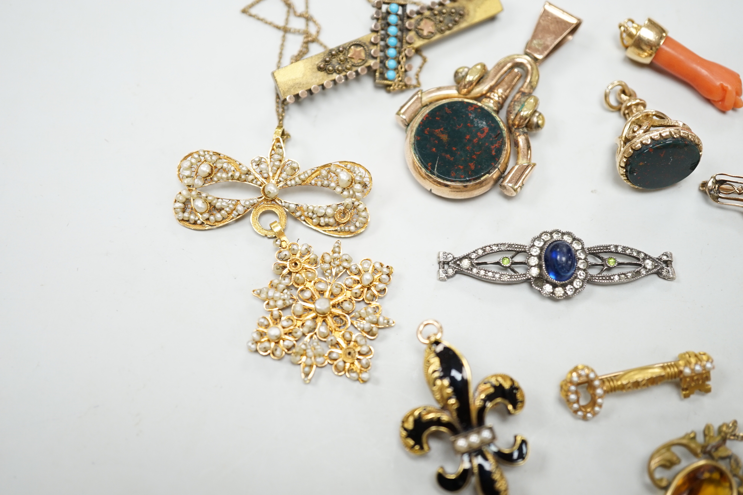 A small group of antique and later jewellery, including 9ct gold and bloodstone fob seal, a 1930's yellow metal and seed pearl set key brooch, 14k and black enamel brooch, spinning fob pendant, coral hand charm, 10k and
